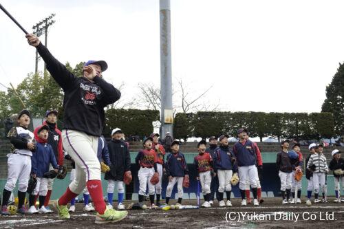 高千穂町総合公園球場で開かれた梅田学園硬式野球部の野球教室。豪快なスイングに歓声を上げる児童たち