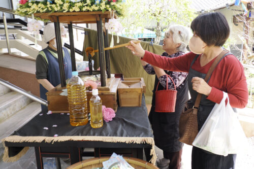 花御堂の釈迦像に甘茶をかける参拝者